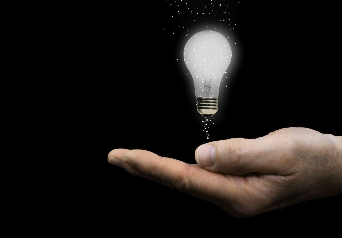 Hand with Floating Light Bulb